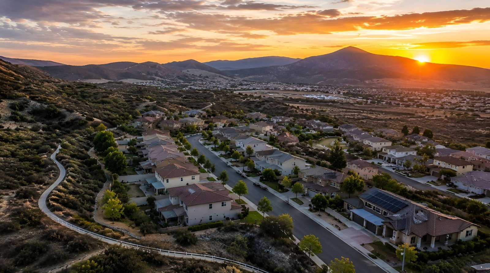 Suburban neighborhood with mountain views at sunset.