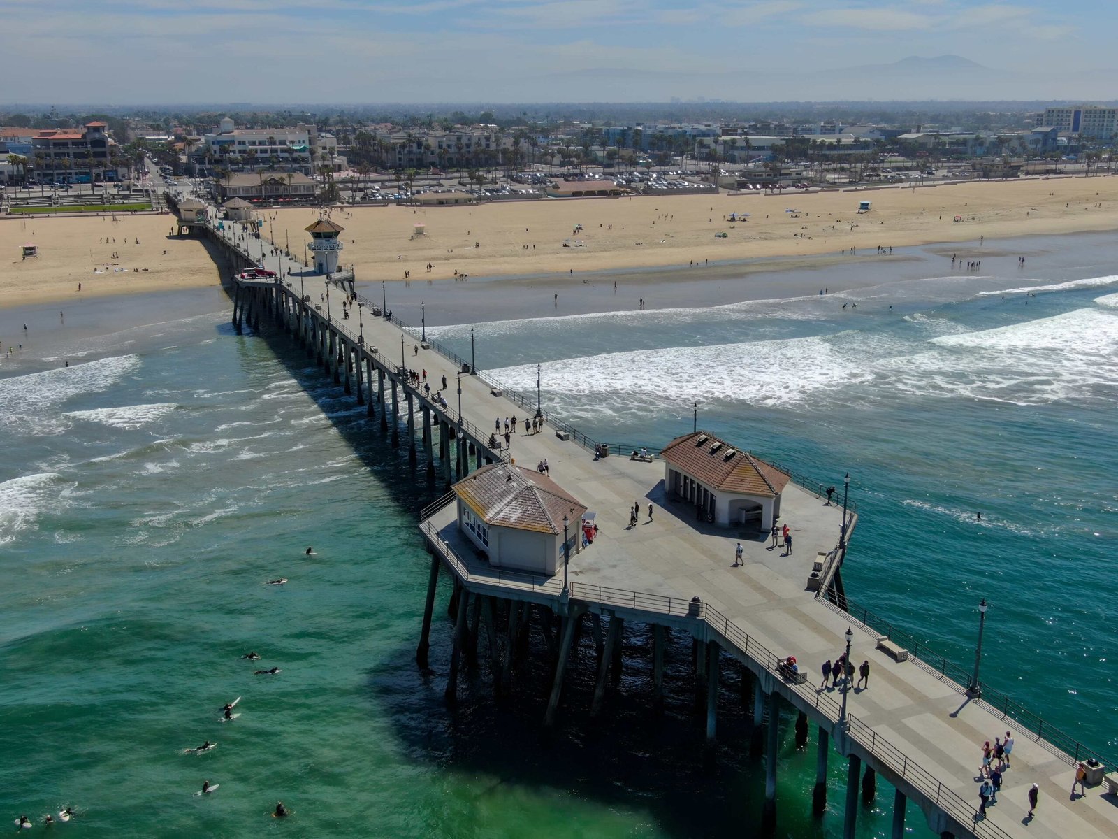 Beach pier with ocean and sandy shoreline.