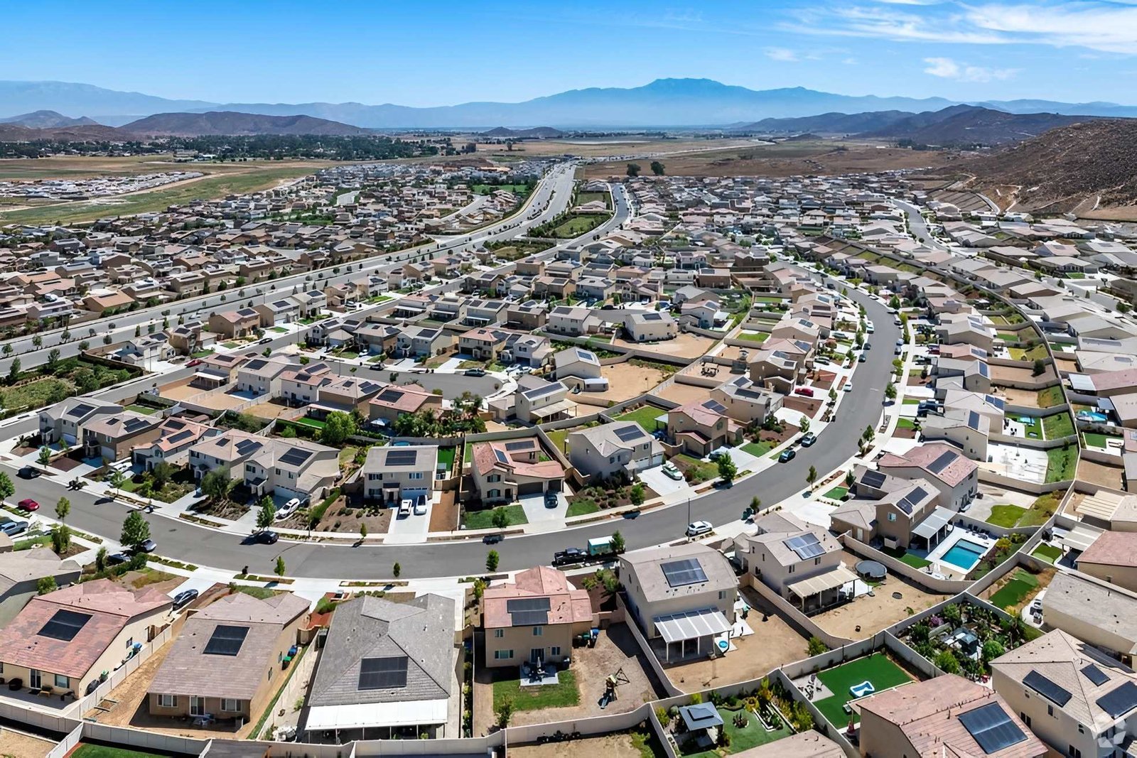 Aerial view of city streets and mountain landscape.