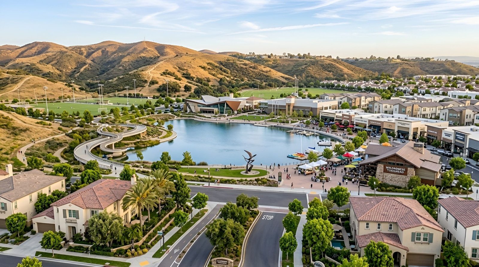 Aerial view of lake, homes, and green hills.