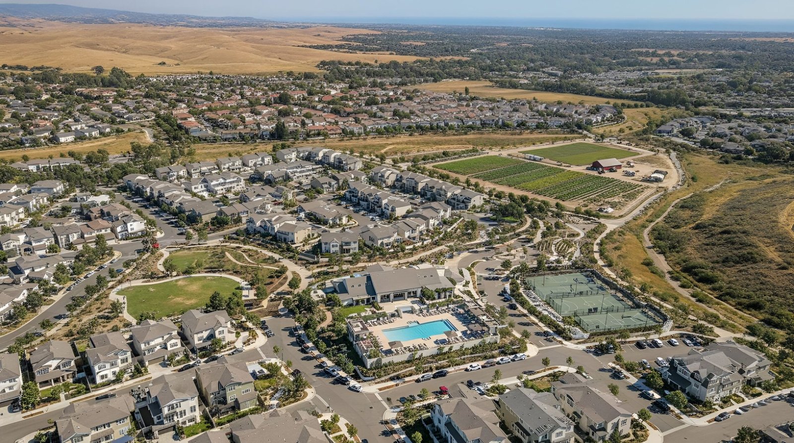 Aerial view of suburban homes and open land.